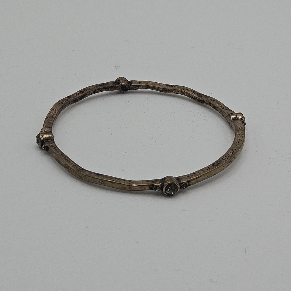 dark gold tone bangle bracelet with gray rhinestone stations